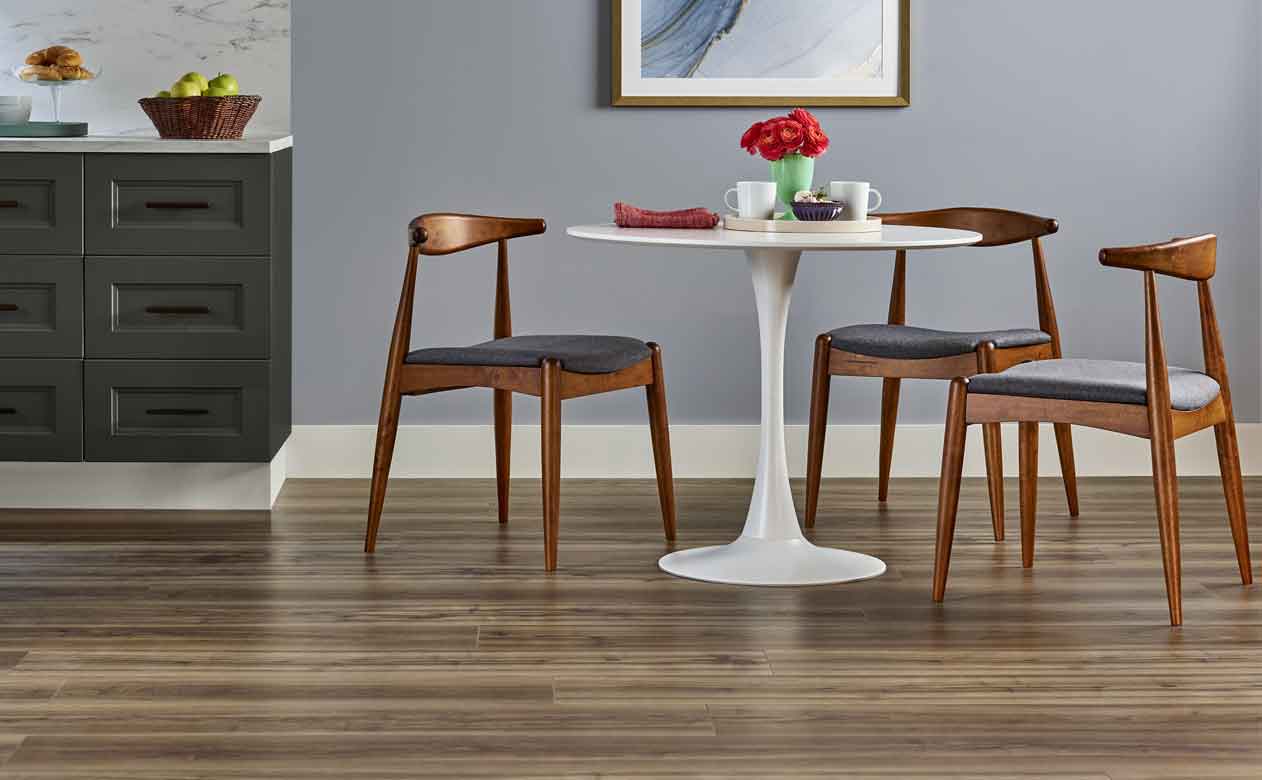 Luxury vinyl plank wood-look flooring in kitchen with white round table and wood chairs